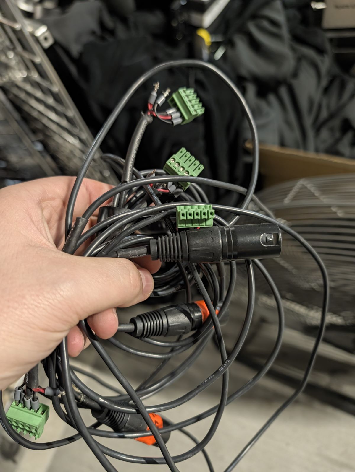 A tangle of cables with green connectors on one end and XLR connectors on the other