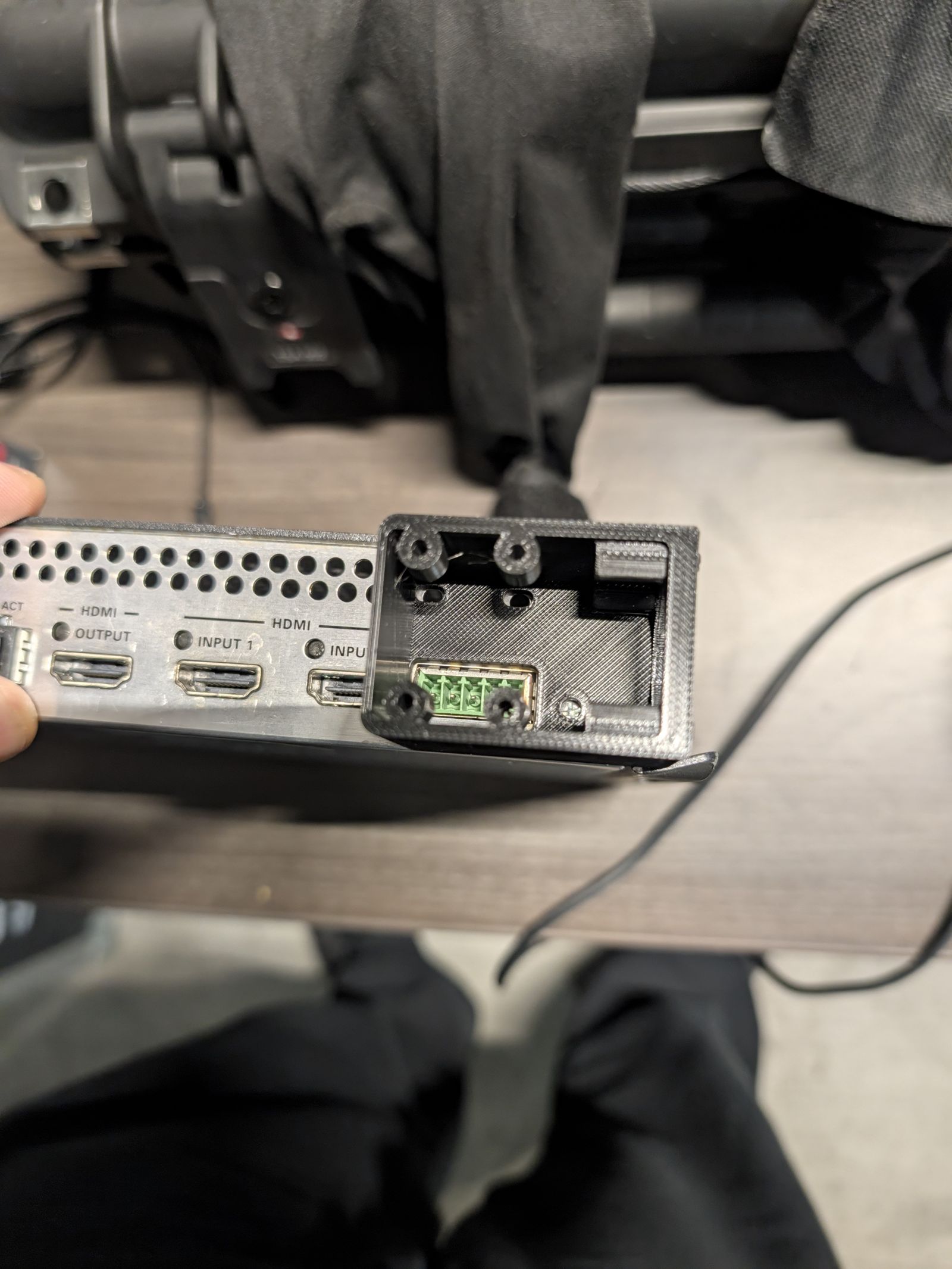 The printed box held next to the Crestron box, with the green connector visible in its window